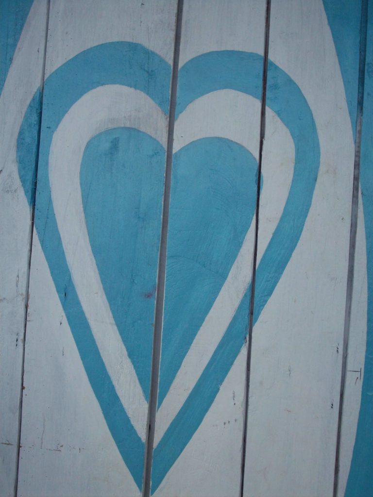 A blue heart painted on wood panels